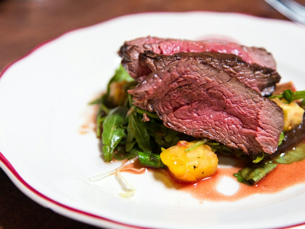 Tender beef fillet cooked rare to perfection with red wine reduction and wild greens